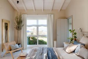 ein Schlafzimmer mit einem Bett und einem großen Fenster in der Unterkunft La Guarida Lugás cabañas de lujo in Villaviciosa