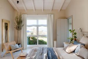 a bedroom with a bed and a large window at La Guarida Lugás cabañas de lujo in Villaviciosa