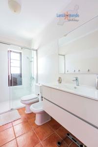 Baño blanco con aseo y lavamanos en Vivienda Vacacional Casa Shanti, en Puerto Calero