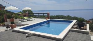 a swimming pool sitting on top of a house at Holiday home Duje in Veliko Brdo