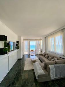 uma sala de estar com um sofá e uma televisão em Luxury Penthouse with Full Sea View em Durrës