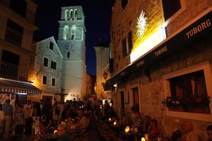 a crowd of people walking down a street at night at The Suites Small Luxury Living 24/7 contactless check in in Vodice