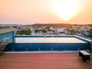 a pool on the roof of a building with the sunset at Radisson Bhopal in Bhopal
