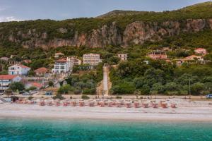 a beach with a group of umbrellas and the ocean at Stellatos House in Póros Kefalonias