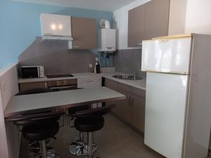a kitchen with a white refrigerator and two bar stools at 100m lac et piste cyclable avec parking gratuit in Sévrier