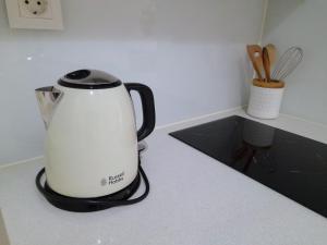 a tea kettle is sitting on a kitchen counter at Light Blue Apartment in Aveiro
