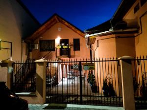 a house with a gate in front of it at Calypso Rooms in Făgăraş