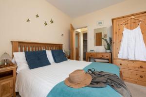 a bedroom with a bed with a hat on it at Cormorant Views, Marazion in Marazion