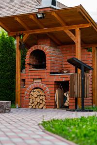 un horno de pizza de ladrillo con techo de madera en Fanni Kulcsosházak en Zetea