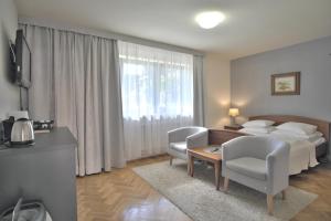 ザコパネにあるPOKOJE "CICHA" ZAKOPANEのベッド、テーブル、椅子が備わるホテルルームです。
