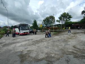um grupo de pessoas em pé na frente de um ônibus em Glamping Alas Duren Yogyakarta em Beran-kidul
