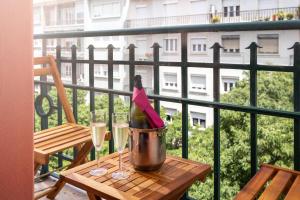 a bottle of wine in a bucket on a table with glasses at Hotel Luena in Lisbon