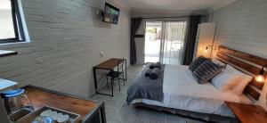 Un dormitorio con una cama y una pared de madera. en STUDIO twenty8, en Burgersdorp