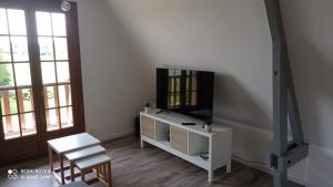 a living room with a tv and a chair at La BELLA 12 - Appartement gite dans maison d'hôtes in Bordeaux-Saint-Clair