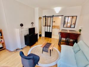 a living room with a blue couch and a table at 2 pièces totalement rénové au cœur de Bourges in Bourges