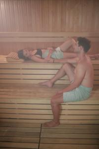 two women and a man sitting in a sauna at Yacht Club in Didim