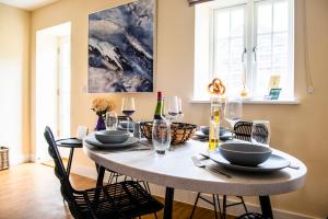 a dining room with a table with chairs and wine glasses at Earls Cottage in Usk