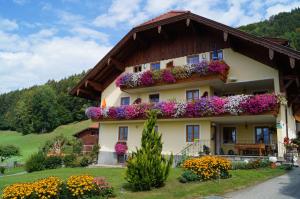 una casa con flores a un lado. en Gesundheitshof Lohninger, en Mondsee