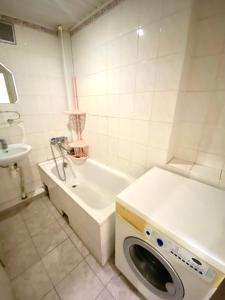 a washing machine in a bathroom next to a sink at Подобово квартира у Львові на вулиці Огієнка 11 біля Залізничного вокзалу in Lviv