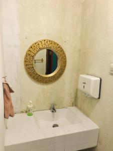 een badkamer met een witte wastafel en een spiegel bij Mendulang Lembang Resort & Resto in Bandung