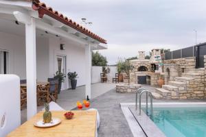 a patio with a table and a swimming pool at Villa Perahori in Sívas