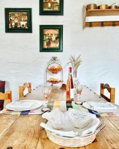 una mesa con platos blancos y botellas de vino. en Monte Carrascal Guesthouse, en Salir