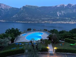 a swimming pool on a hill with a view of a lake at Residence Hotel Maxi in Tremosine Sul Garda