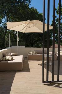 une terrasse avec un parasol et des canapés dans l'établissement Tesoro Nascosto B&B, à Salerne