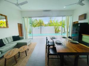 a living room with a dining table and a couch at Villa Kurma, Modern & Tropical, 2BR, Near Fisherman Village in Bophut 