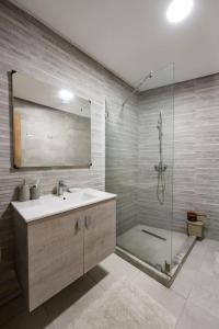 ein Bad mit einem Waschbecken und einer Dusche mit einem Spiegel in der Unterkunft Champs Elysee in Casablanca