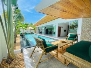 a patio with a table and chairs and a swimming pool at Villa Kurma, Modern & Tropical, 2BR, Near Fisherman Village in Bophut 