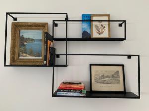 a wall with shelves with pictures and books at Viv, The in Wellington