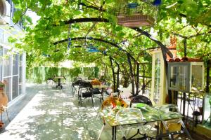 ein Gewächshaus mit Tischen und Stühlen unter einem Baum in der Unterkunft Balim Sultany in Cesme