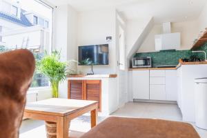 een woonkamer met een tafel en een keuken bij Kelp in Egmond aan Zee