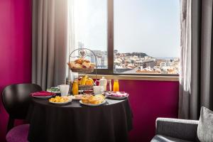 a table topped with plates of food and drinks at Hotel Luena in Lisbon