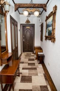 um corredor com uma porta de madeira e um piso de azulejo em Апартаменты центр Головная em Chernivtsi