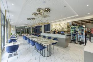 ein Restaurant mit einer Bar mit blauen Stühlen und Tischen in der Unterkunft Hotel Jastarnia in Jastarnia