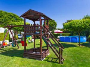 a wooden playground with a slide in a park at Domki u Ewy in Wrzosowo