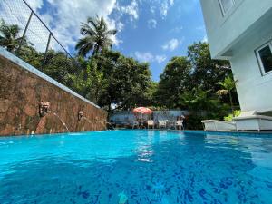 De Amour - A Dreamy Getaway in Anjuna في أنجونا: مسبح ازرق كبير مع نافورة ماء