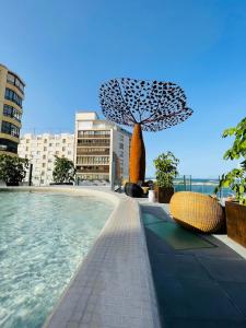 a pool with a tree in the middle of a city at Maison Marineta in Denia