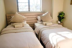 duas camas sentadas uma ao lado da outra num quarto em Serene Luxury retreat in Cullinan em Cullinan