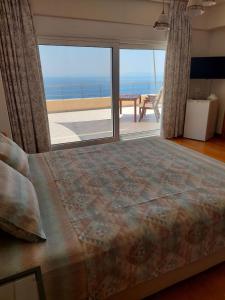 a bedroom with a bed and a view of the ocean at Viva B&B in Anavyssos