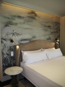 um quarto com uma cama com um quadro na parede em Maison Marineta em Denia