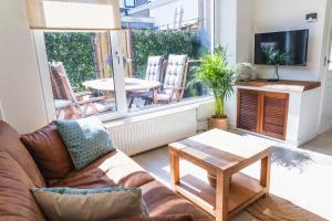 sala de estar con sofá y mesa en Kelp, en Egmond aan Zee