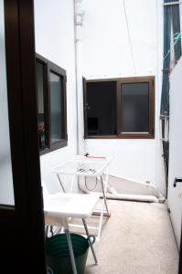 un patio con 2 sillas, una mesa y una ventana en Room in My White House, en Las Palmas de Gran Canaria