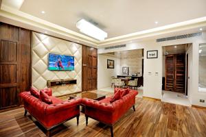 a living room with two red chairs and a table at Hotel Vintage Zirakpur Chandigarh in Panchkula