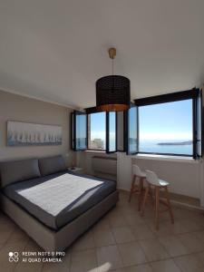 a bedroom with a bed and two windows at Villa Altomare in Otranto