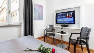 a living room with a tv and a table and chairs at Persia Collection Trevi in Rome