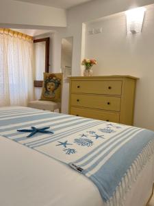 a bedroom with a bed with a blue and white blanket at Duchessa House in Castellammare del Golfo