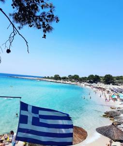 a blue and white flag on a beach with people at Ambra in Astris